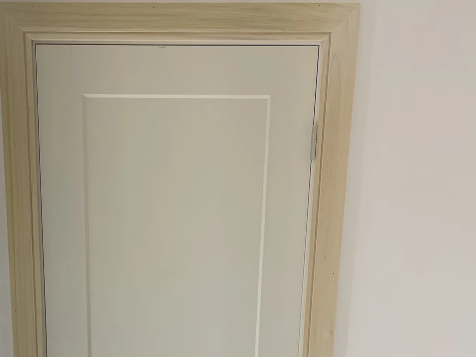 Painted two-panel interior door with head casing, hinge side
