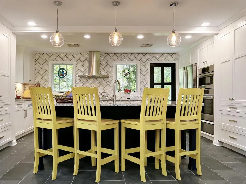 Remodeled white kitchen with island and pendant lights