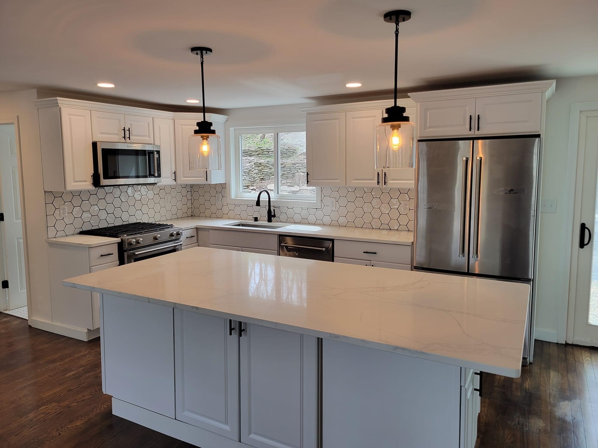 A kitchen with white cabinets, hex-tile backsplash and an island, Reading