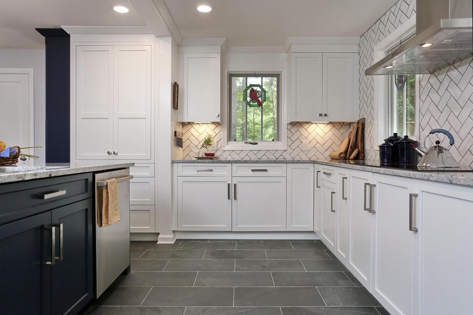 Kitchen range wall with herringbone tile backsplash and a stained-glass cardinal window