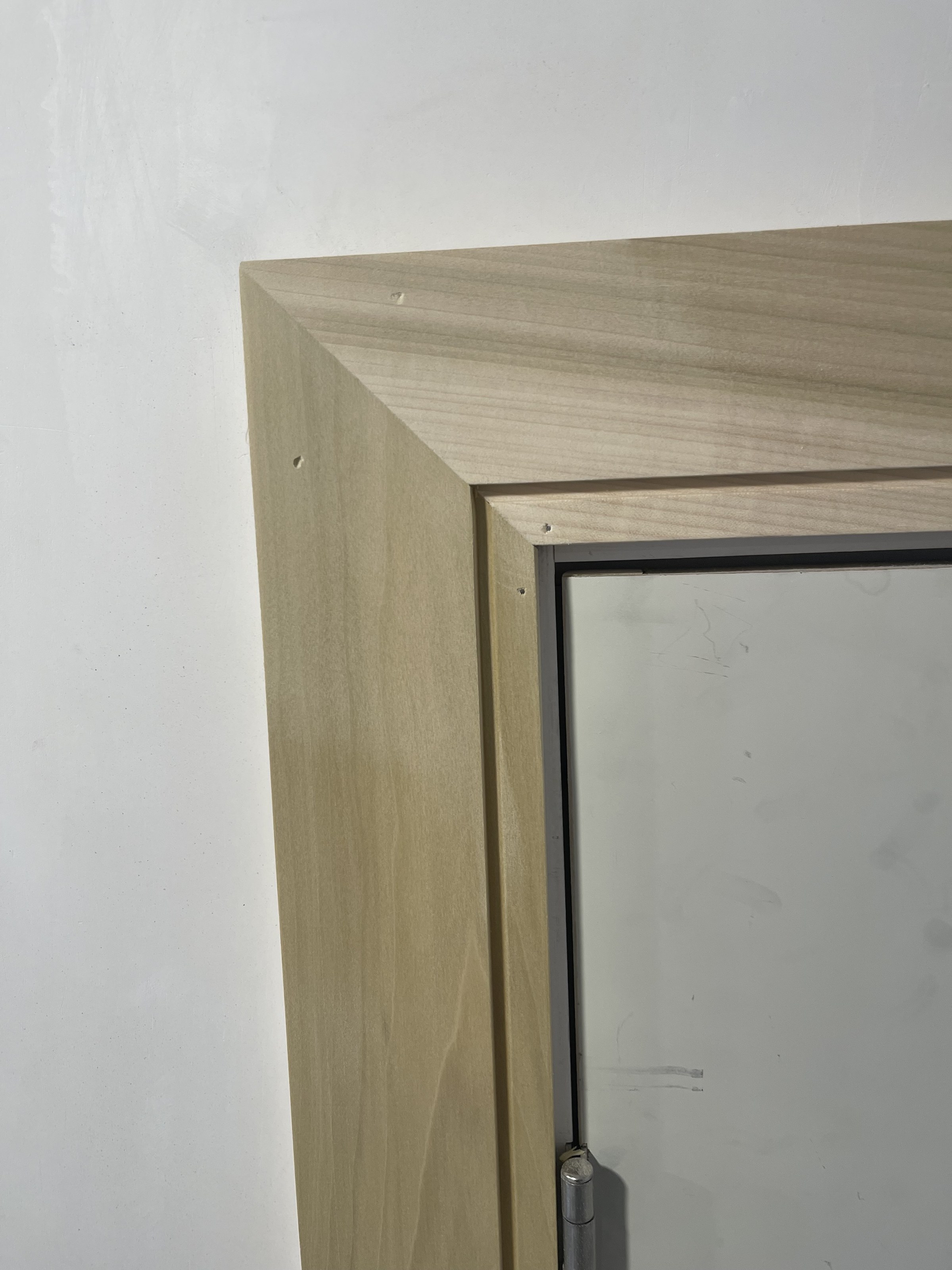 Mitered corner joint of a window casing in raw, unpainted wood, during construction, Reading