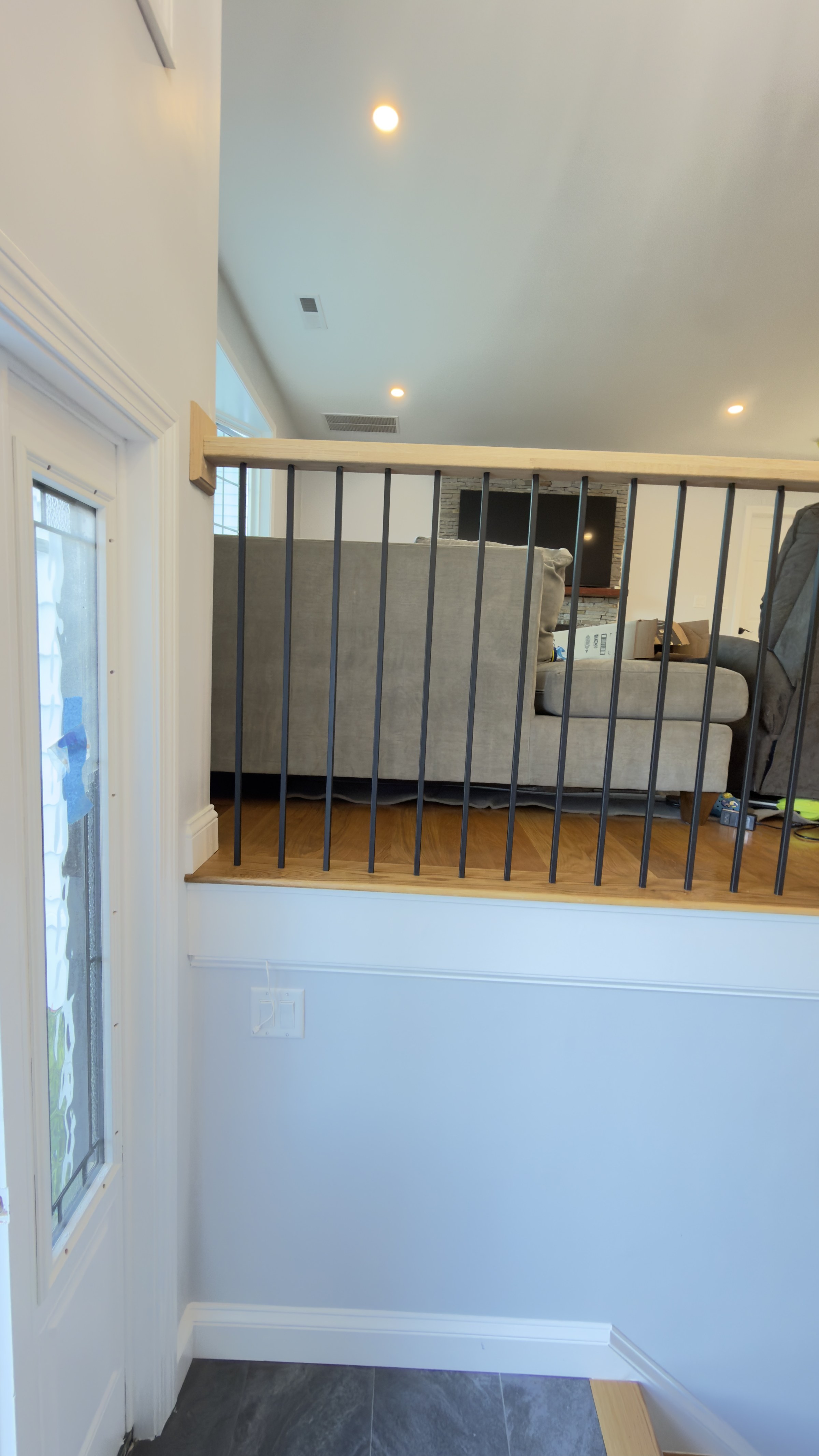 Close detail of the white oak rail and black metal balusters at the landing