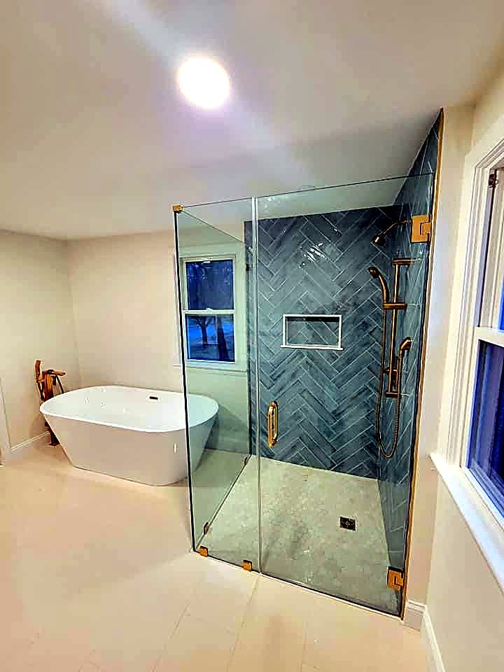 Teal herringbone-tile shower with a gold floor-mount tub filler and freestanding oval tub, Middleton