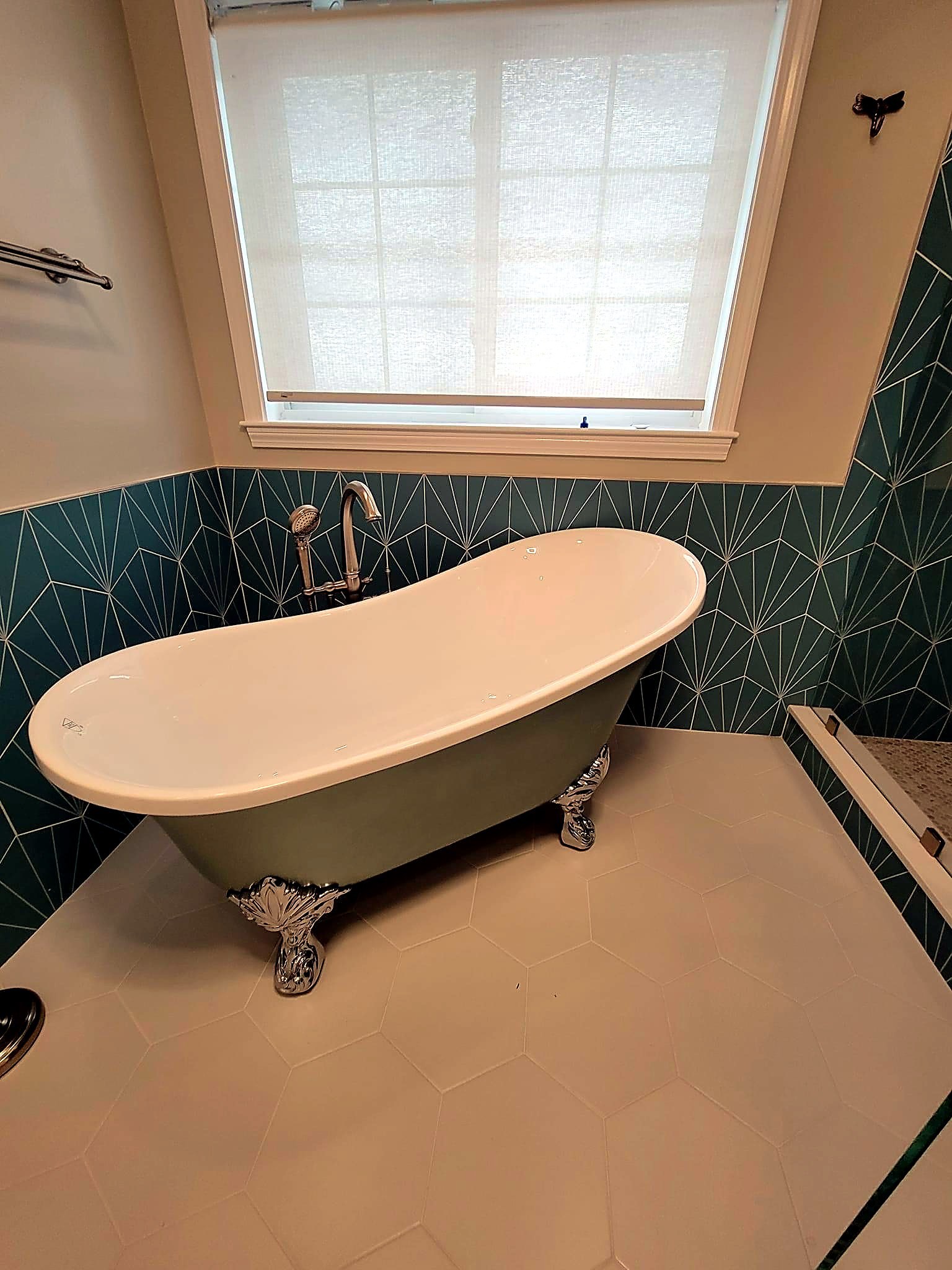 Green clawfoot slipper tub against teal fan-pattern tile, North Reading