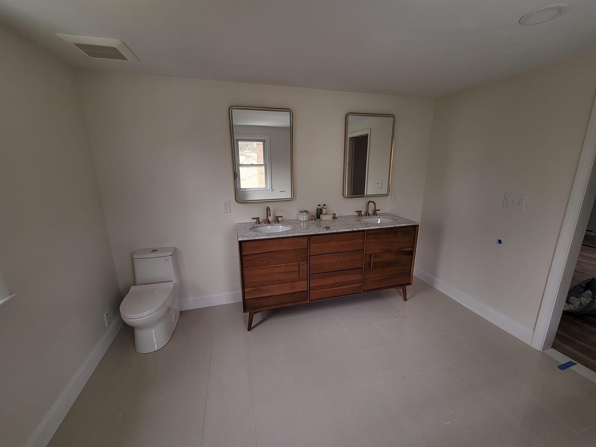 Mid-century double-sink walnut vanity with brass fixtures and gold-framed mirrors, Middleton