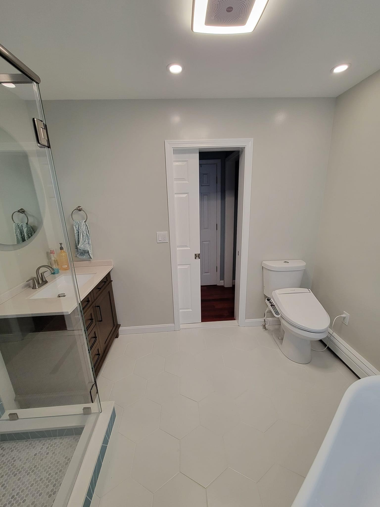 Primary bath with a frameless glass shower, dark hex floor and a dark wood vanity, Peabody