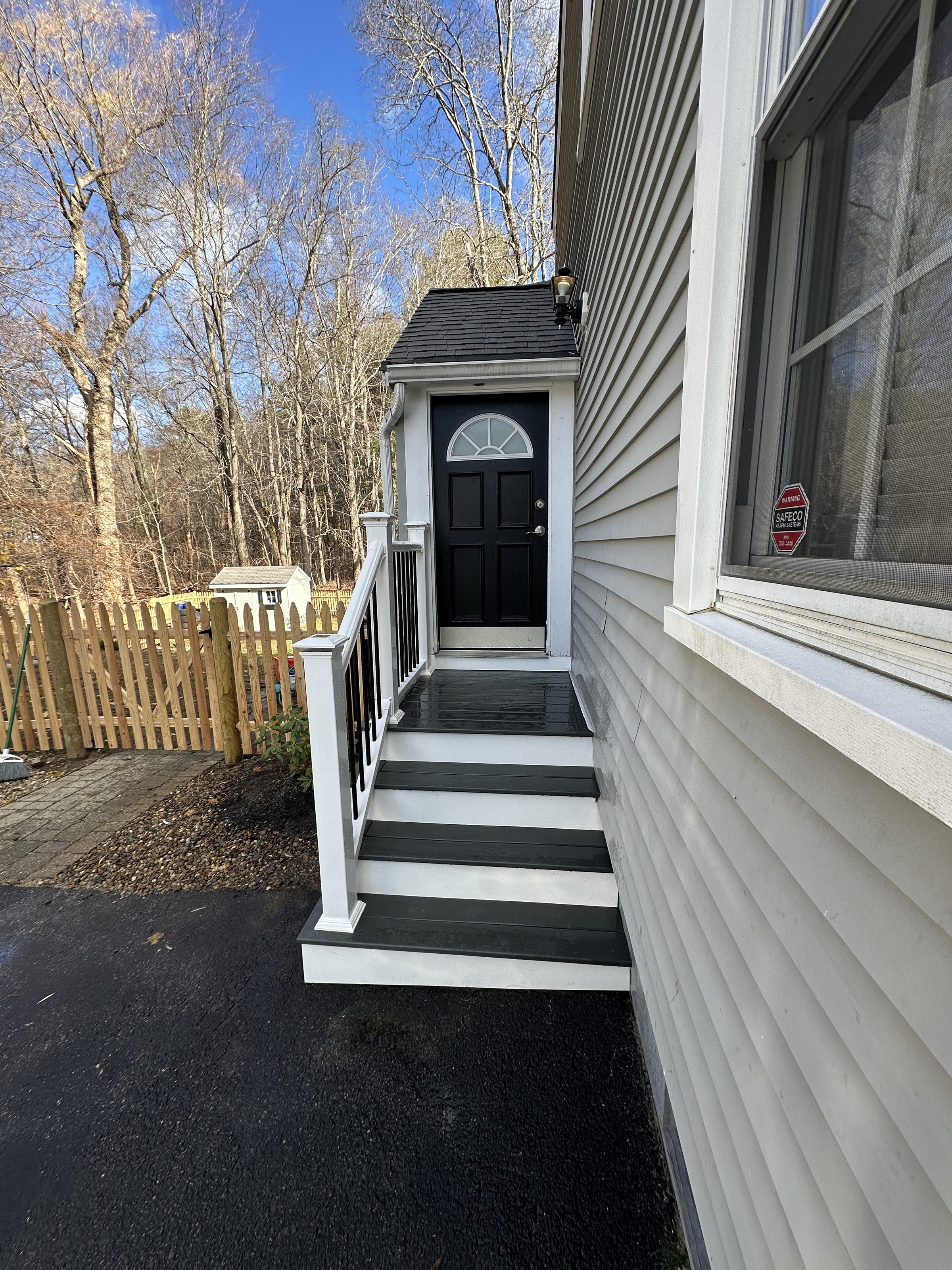 Wide establishing view of the black composite-tread entry steps with white risers and black balusters, Reading