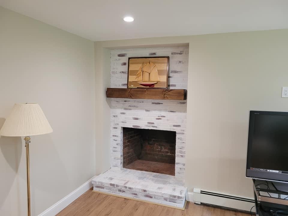 Whitewashed brick fireplace with a rough-hewn wood mantel, Lynnfield