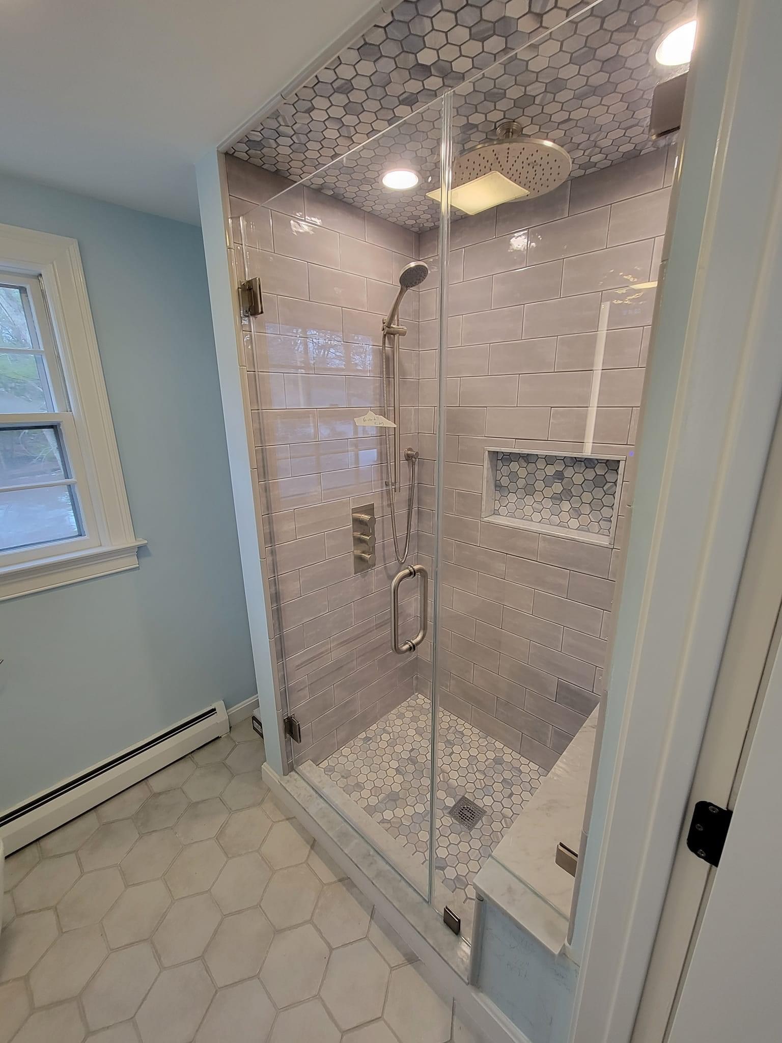 Gray subway-tile shower with a rain head, hex-mosaic ceiling accent and marble bench, Winthrop