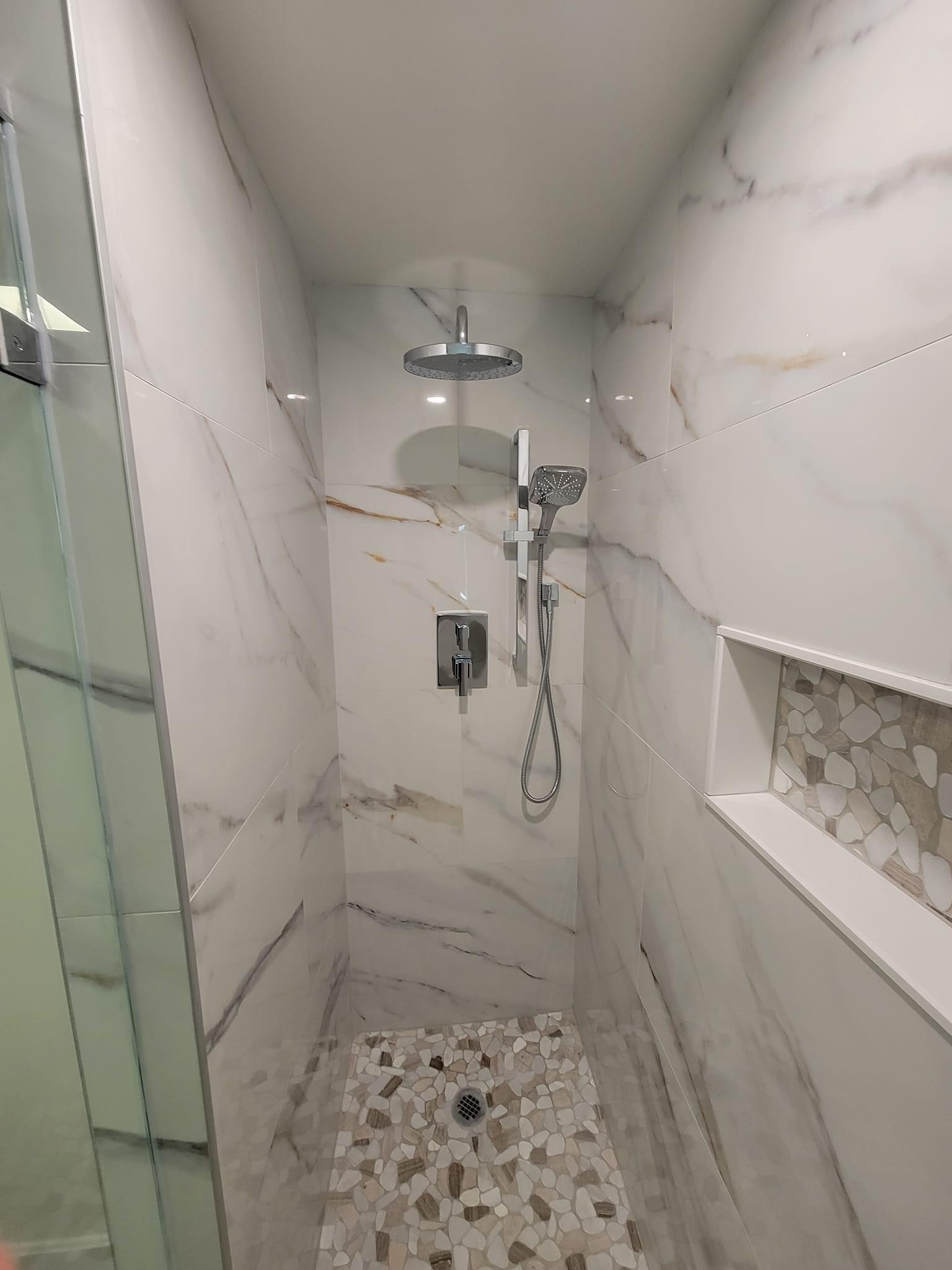 Marble-look shower with a pebble-mosaic niche, full run and rain head, Saugus